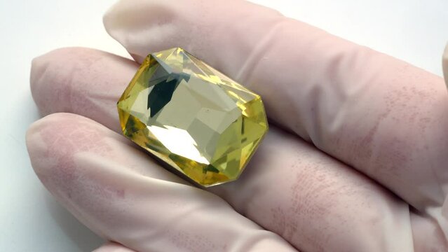 gemologist or gemstones dealer evaluating a big yellow pure gemstone. Pawnshop concept