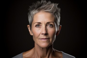 Portrait of a beautiful senior woman with short hair on a dark background