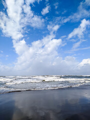 Obraz premium Parangtritis beach. The expanse of beach waves with bright white clouds makes the beach beautiful