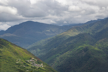 Obraz premium High mountains slopes covered in thick virgin forest and shrouded in cloud near the small village of senge near tawang in western arunachal pradesh, India.