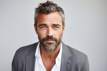 Portrait of handsome mature man with grey hair and beard looking at camera - obrazy, fototapety, plakaty
