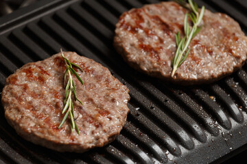 Burger cutlets are fried on a smart electric grill, homemade burgers.