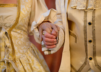 hands of the aristocratic man and woman during the ceremony with luxurious historical period clothes
