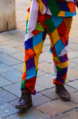 legs of the man disguised as Harlequin the Italian mask during the Carnival