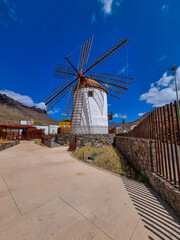 An old Wind Mill and some oversized pots cans coffee grinders in Mogan on Gran Canaria Island...