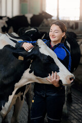 Happy young woman farm worker hugging cow as sign of concern for animal health care. Concept...