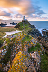 Beautiful sunrise long exposure at Ynys Llanddwyn Island lighthouse on coast of Anglesey, North Wales, UK. - 738682315