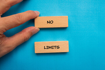 No limits words written on wooden blocks with blue background. Conceptual symbol. Copy space.