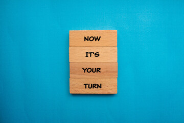 Now it's your turn words written on wooden blocks with blue background. Conceptual business symbol....
