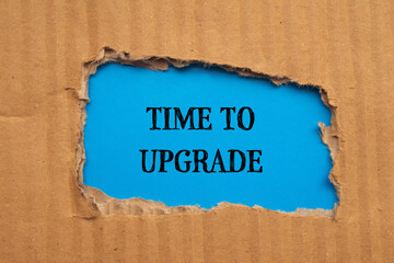 Time to upgrade words written on torn cardboard paper with blue background. Conceptual symbol. Copy space.