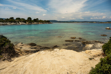 Panoramic view of Karidi beach. Vourvourou, Sithonia, Greece, Halkidiki. Wild beautiful beach with turquoise water. Mediterranean panorama landscape of Karidi sandy beach with pine tree  on coast.
