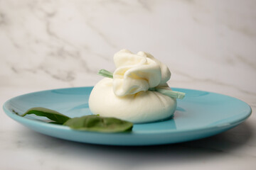 Burrata and basil on a plate, Italian cheese delight, stracciatella filling, creamy texture