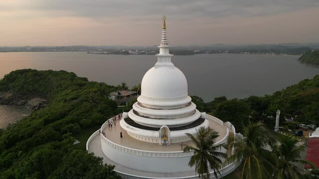 White pagoda buddhist temple among the jungle. Japanese Peace Pagoda in Sri Lanka aerial view.
