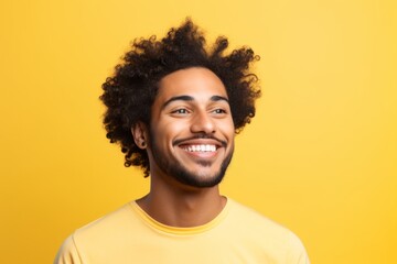 Fototapeta na wymiar Portrait of smiling afro american man with curly hair on yellow background