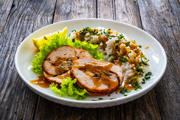 Stuffed turkey breast roulade with dried apricots and cranberries and boiled white rice on wooden...