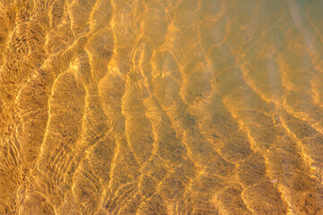 Ripples glinting in the sun in shallow water on a pond