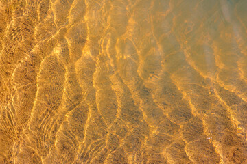 Ripples glinting in the sun in shallow water on a pond