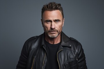 Portrait of a serious mature man in a black leather jacket.