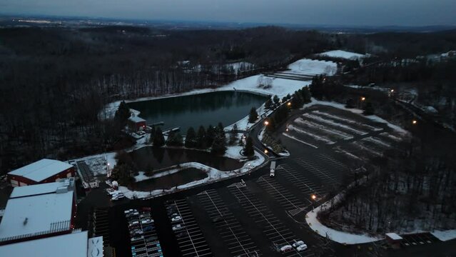 Drone shot of lake and parking lot in front of a mountain resort in Pocono Mountains in winter, USA