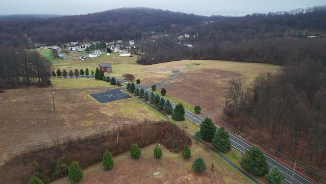 Drone of a road in rural landscape with dense trees around and countryside houses in Poconos