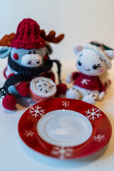 Various homemade cookies from the Christmas bakery on a small plate. And a moose and a cat amigurumi figures with Christmas clothes.