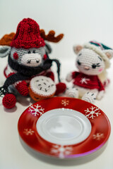 Various homemade cookies from the Christmas bakery on a small plate. And a moose and a cat amigurumi figures with Christmas clothes.