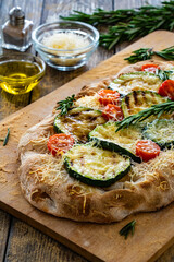 Pinsa Romana with mozzarella cheese and grilled zucchini and rosemary on wooden table