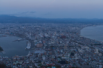 Fototapeta premium 日本 北海道函館市にある函館山展望台から見える夕暮れ時の市街地の街並みと津軽海峡