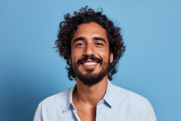 Portrait of handsome man with curly hair, isolated on blue background