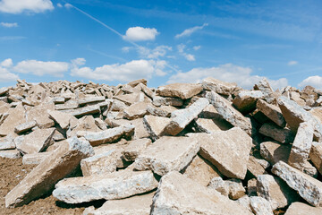 Dump of concrete debris piles on the ground in vineyards area nature with cloudy sky. large pile of...
