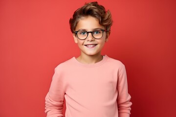 Portrait of a cute little boy in glasses on a red background