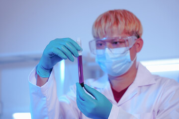 Asian middle-aged male scientist conducts research in a laboratory, surrounded by petri dishes and...