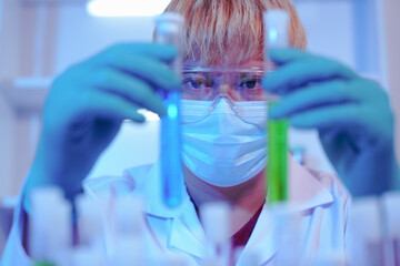 Asian middle-aged male scientist conducts research in a laboratory, surrounded by petri dishes and...