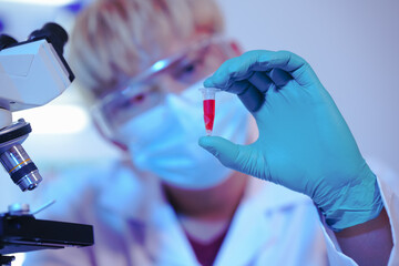 Asian middle-aged male scientist conducts research in a laboratory, surrounded by petri dishes and...