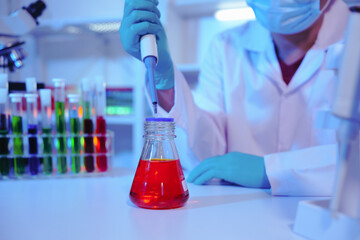 Asian middle-aged male scientist conducts research in a laboratory, surrounded by petri dishes and beakers. Investigate the chemistry of gasoline, food ingredients, perfumes, viruses, and medicine