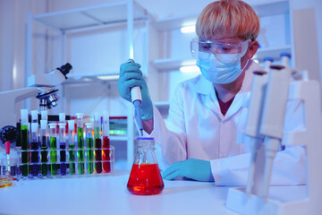Asian middle-aged male scientist conducts research in a laboratory, surrounded by petri dishes and...