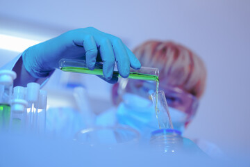 Asian middle-aged male scientist conducts research in a laboratory, surrounded by petri dishes and...