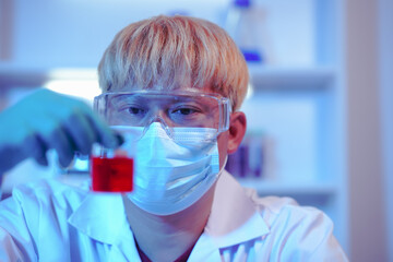 Asian middle-aged male scientist conducts research in a laboratory, surrounded by petri dishes and...