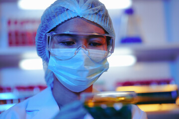 Asian female scientist passionately conducts experiments in a laboratory, surrounded by petri...