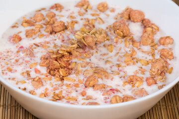 Muesli with dried fruits drenched in milk in bowl