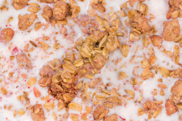 Muesli with dried fruits drenched in milk close-up
