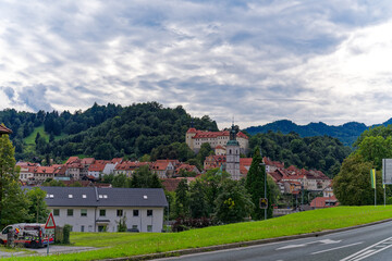 Fototapeta na wymiar Old town with historic houses and castle on a hill at Slovenian City of Skofja Loka on a cloudy summer day. Photo taken August 9th, 2023, Skofja Loka, Slovenia.