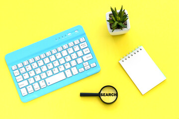 Notepad, magnifying glass on the background.magnifying glass with the word search.