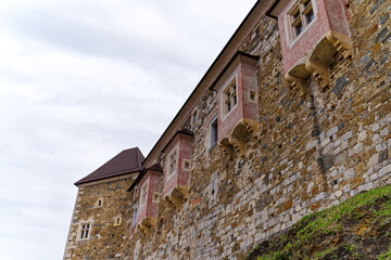 Looking up stone wall and tower with loophole of Castle of Ljubljana on a cloudy summer day. Photo...