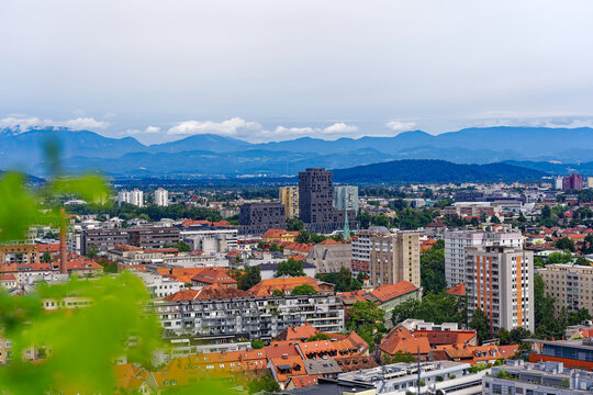 Aerial view of City of Ljubljana seen from Sance castle hill with mountain panorama in the background on a cloudy summer day. Photo taken August 9th, 2023, Ljubljana, Slovenia.