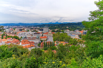 Aerial view of City of Ljubljana seen from Sance castle hill with mountain panorama in the background on a cloudy summer day. Photo taken August 9th, 2023, Ljubljana, Slovenia.