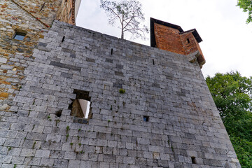 Looking up stone wall and tower of Castle of Ljubljana on a cloudy summer day. Photo taken August...