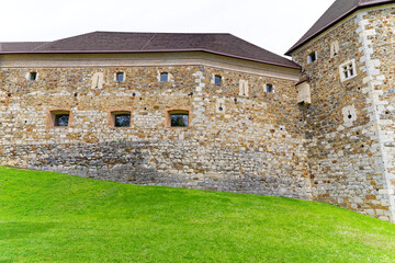 Looking up stone wall and tower of Castle of Ljubljana on a cloudy summer day. Photo taken August...
