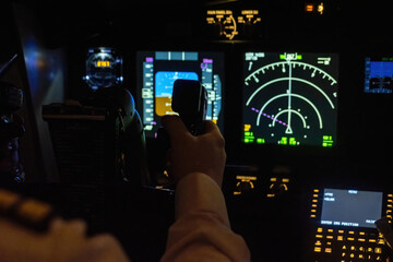 Man holds aircraft helm located near navigation system. Professional captain grasps control yoke in...