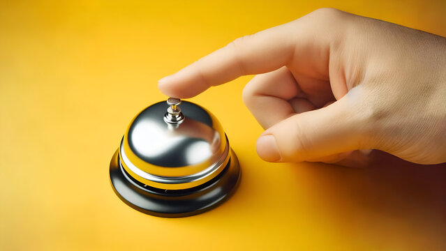 Hand ringing the bell on a yellow background